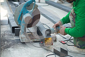 Worker cutting aluzinc metal sheet at building site construction