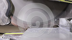 Worker cutting baseboard on the circular saw before installing