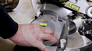 Worker cutting baseboard on the circular saw before installing