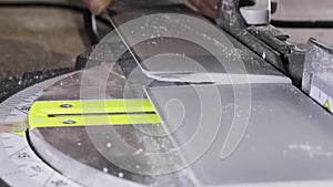 Worker cutting baseboard on the circular saw before installing