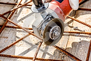 Worker cutting construction stee netl with Angle Grinder Mashin