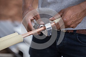Worker cutting copper pipe of air conditioner