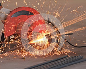 Worker cutting deformed bar with spark