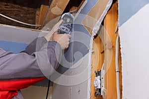 Worker cutting drywall plasterboard with a using multi tool