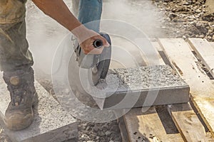 Worker with a cutting flex cuts a concrete curb