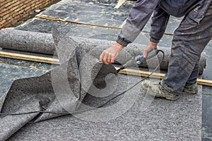 Worker cutting insulation material for basement wall