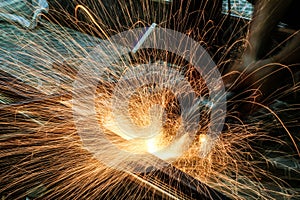 Worker cutting metal with grinder. Sparks while grinding iron