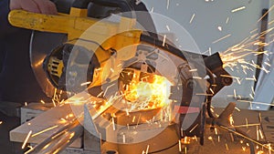 Worker cutting metal with grinder. Sparks while grinding iron