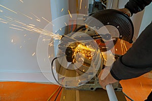 Worker cutting metal with grinder. Sparks while grinding iron