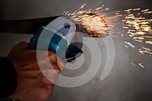 Worker cutting metal with knife. Sparks while knife iron.