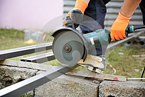 Worker cutting metal pole in construction zone