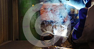 Worker cutting metalsheet by acetylene torch with bright sparks