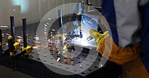 Worker cutting metalsheet by acetylene torch with bright sparks
