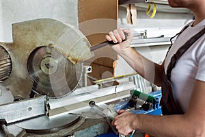 Worker cutting PVC profile with circular saw