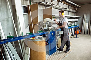 Worker cutting PVC profile with circular saw