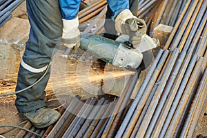 Worker cutting rebar by grinding machine