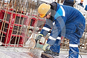 Worker cutting rebar by grinding machine