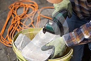 Worker cutting roof tiles with circular saw machine