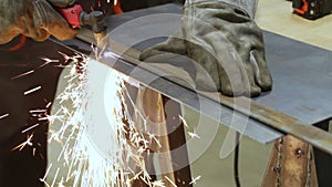 Worker cutting sheet of metal with plasma cutter, using metal line for strict cut.