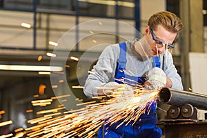 Worker cutting steel with angle grinder