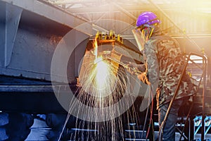 Worker cutting steel with light under ship Repair.