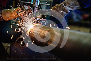 Worker cutting steel pipe with acetylene welding cutting torch a