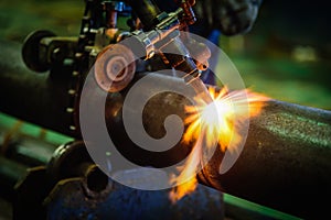 Worker cutting steel pipe with acetylene welding cutting torch a