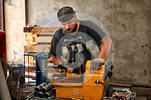 Worker cutting steel pipe with machine for threading