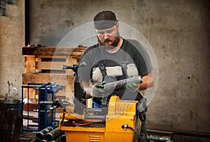 Worker cutting steel pipe with machine for threading