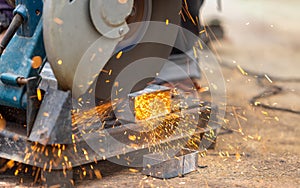 Worker cutting steel rectangular pipe in construction site
