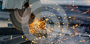 Worker cutting steel rectangular pipe in construction site