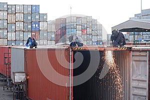 Worker cutting steel sheet by gas cutting, repair container box job