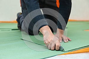 Worker cutting underlayment