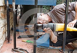 Worker Cutting Wrought Iron Post