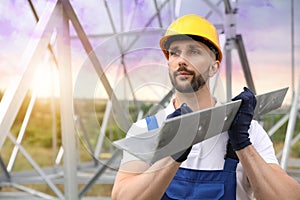 Worker with detail from high voltage tower construction on building site. Installation of electrical substation