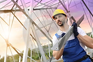 Worker with detail from high voltage tower construction on building site. Installation of electrical substation