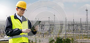 Worker with digital tablet on a background of power station