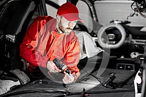 Worker disassembling car interior