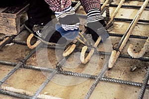 Worker doing steelwork for reinforcement of concrete floor photo
