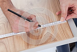 Worker drawing a mark on laminate