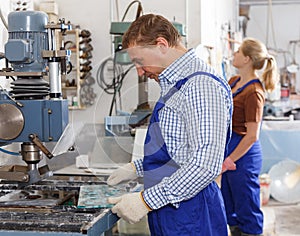 Worker drilling bores in glass on machine