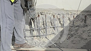 Worker are drilling concrete on construction site with pneumatic hammer drill. Builder worker uses a jackhammer on demolition site