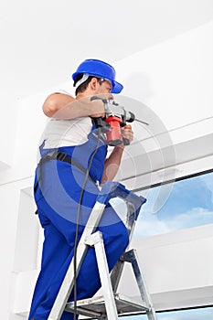 Worker drilling hole in wall