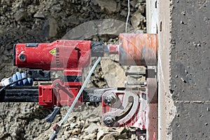 Worker is drilling to concrete wall with core drill machine. Core drills used in metal are called annular cutters.