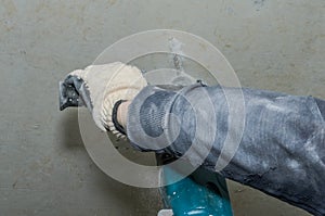 Worker drills a concrete wall with a hammer drill