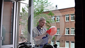 A worker drinks a hot drink from a black mug against a brick building.