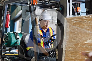 Worker driver at warehouse forklift loader works to containers box, worker man in warehouse with forklift