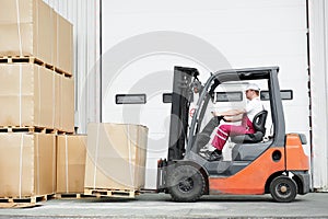 Worker driver at warehouse forklift loader works