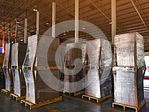 Worker driving forklift loading shipment carton boxes goods on wooden pallet at loading dock from container truck to warehouse