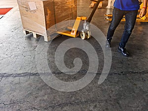 Worker driving forklift loading shipment carton boxes goods on wooden pallet at loading dock from container truck to warehouse car